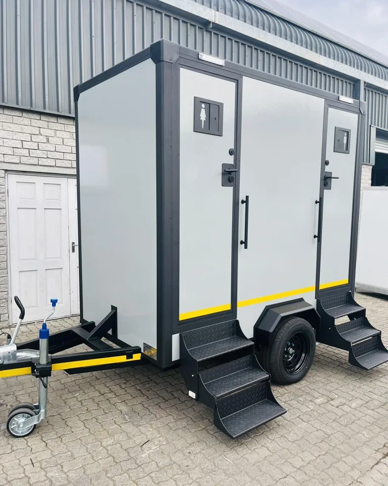 Two-door gray restroom trailer with exterior stairs