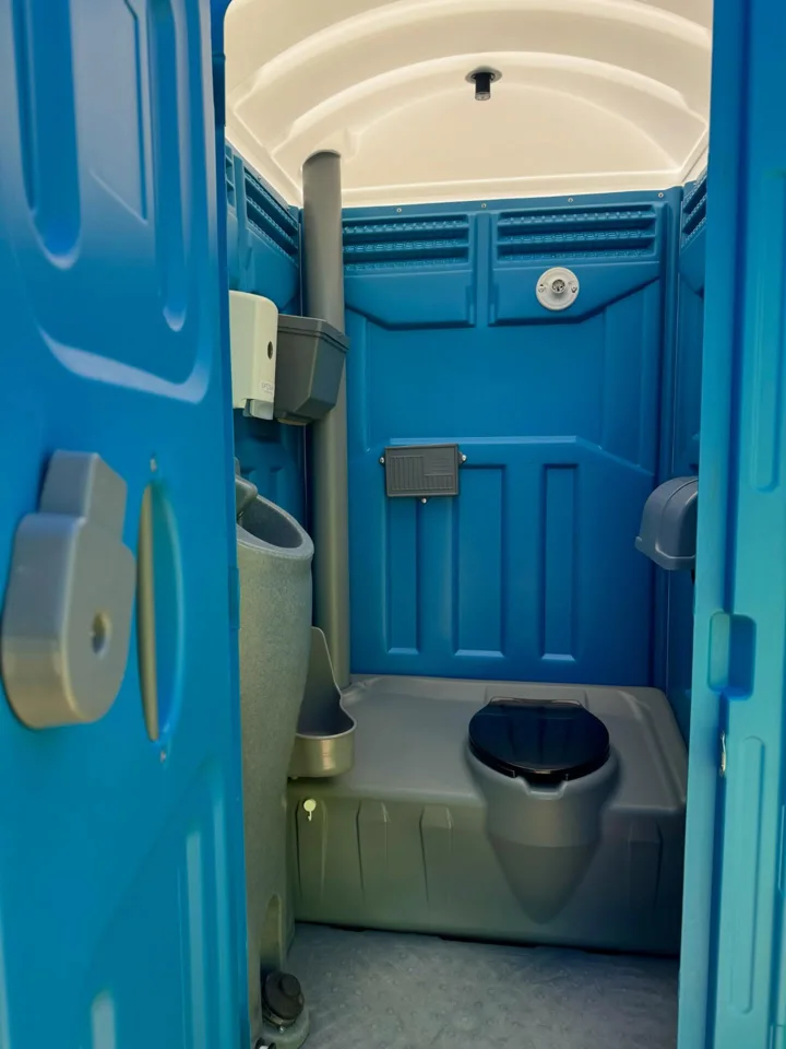 Blue portable toilet interior with a non-flushing toilet and urinal