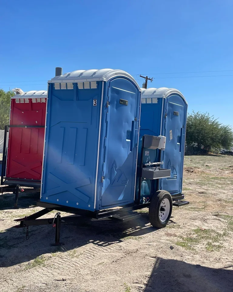 Blue portable toilets mounted on a transport trailer