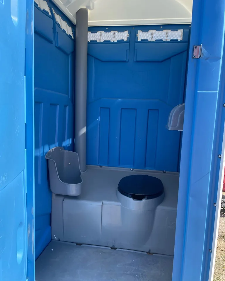 Open doorway showing a blue portable toilet and urinal