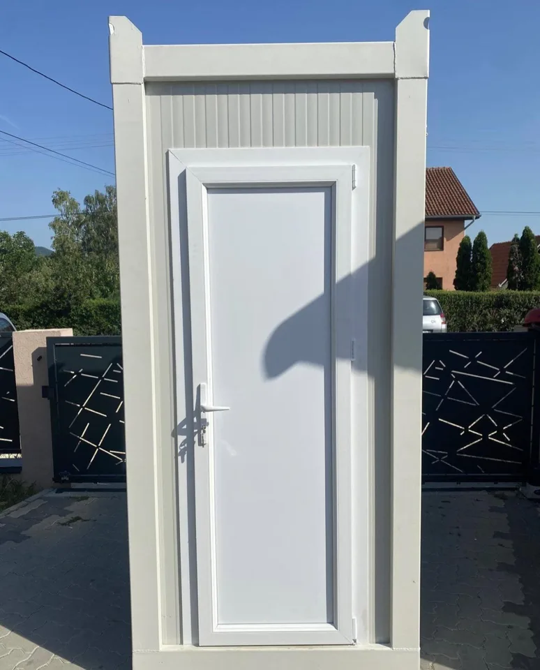 Front view of a gray portable toilet with a closed door