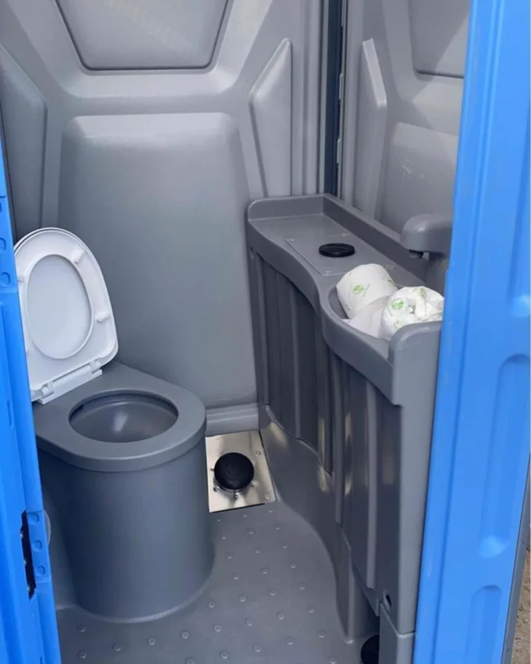 Portable restroom interior with toilet, urinal and handwashing sink