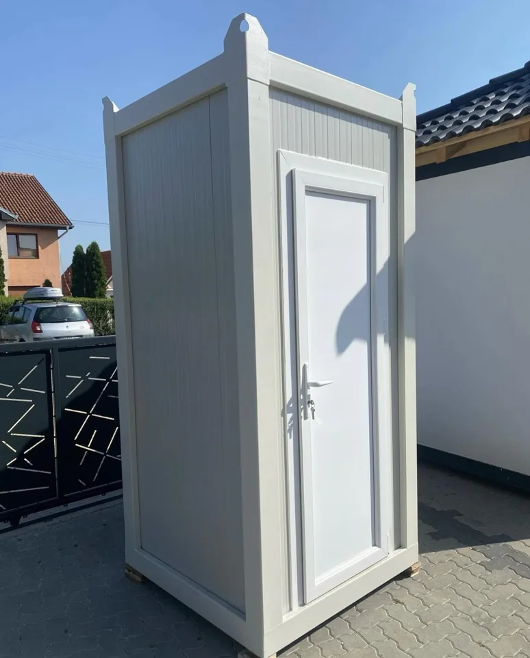 Gray portable toilet with roof vents and a closed entry door