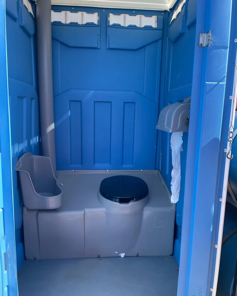 Blue portable restroom interior with toilet and urinal
